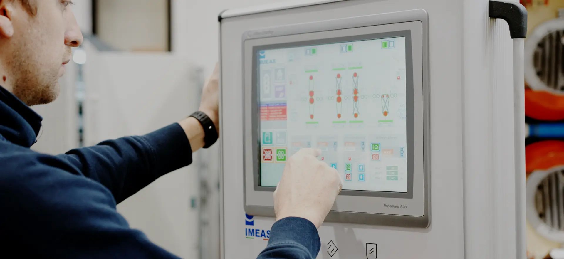 Operatore che con il dito seleziona una funzionalità dal pannello touchscreen della macchina