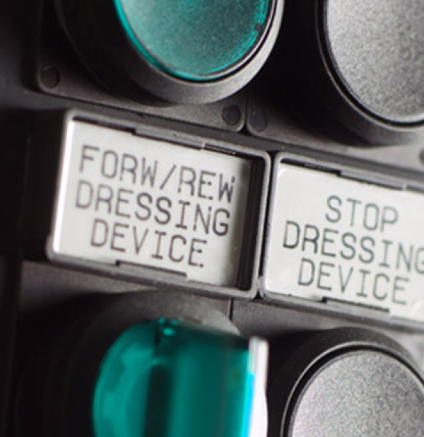 Pulsanti macchina con scritte: 'FORM/REW DRESSING DEVICE' e 'STOP DRESSING DEVICE