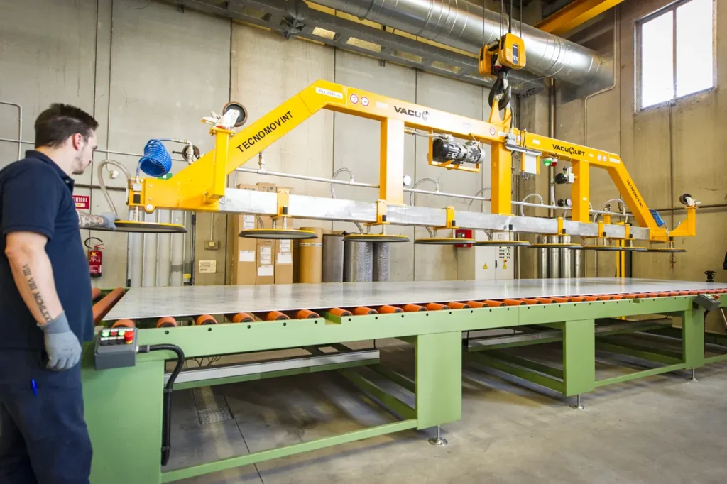 Operaio che lavora con un macchinario giallo a forma di ponte