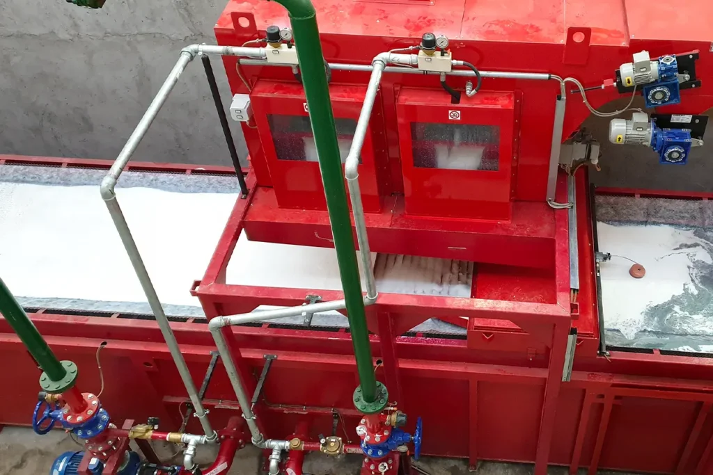 visione dall'alto di u macchinario rosso, con dei tubi collegati a delle valvole che a loro volta sono collegati con il macchinario
